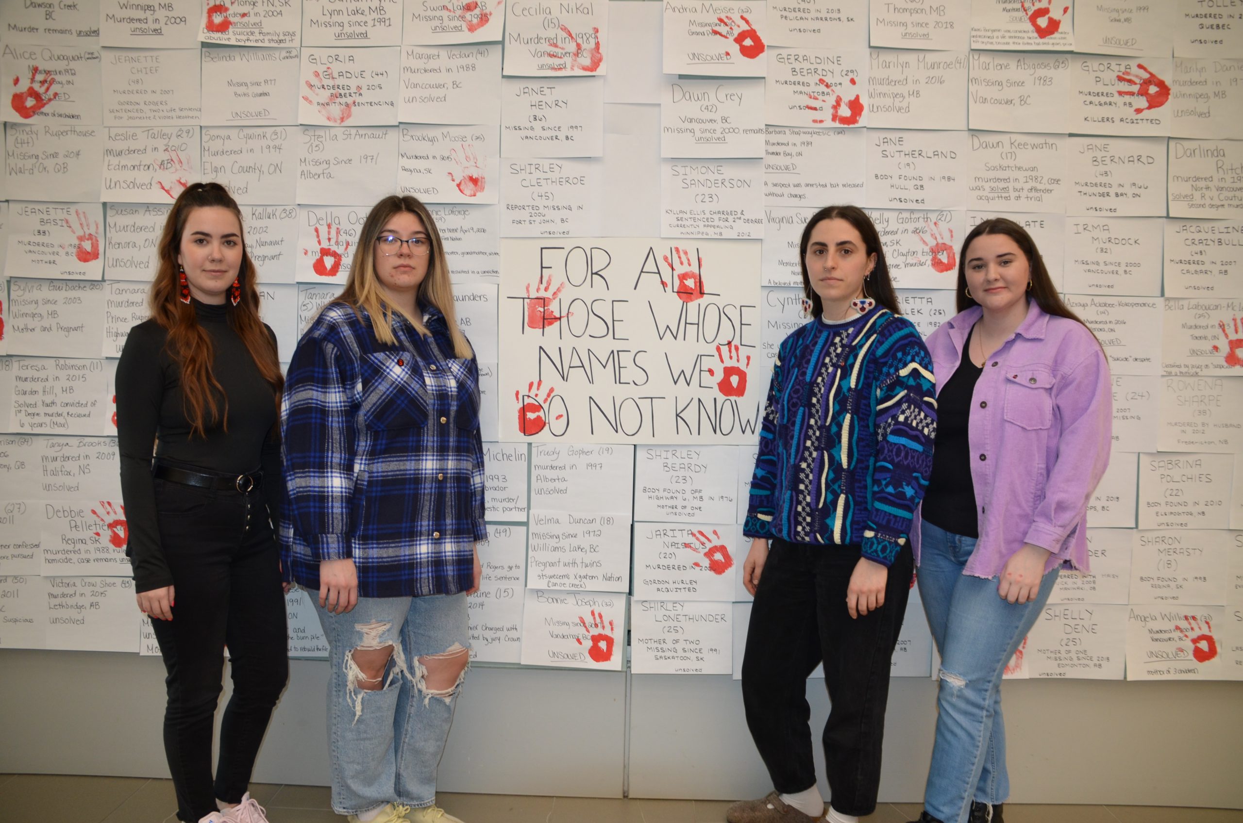 Photo of four members of the Osgoode Indigenous Students' Association who organized Osgoode Red Dress Week in honour of murdered and missing Indigenous women.